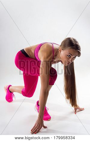A Woman Dressed In Sportswear Prepared To Run. Studio. White Background.
