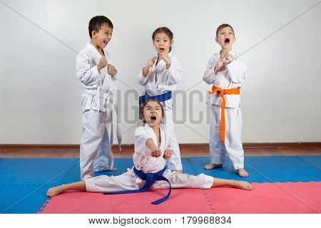 Four children demonstrate martial arts working together. Fighting position active lifestyle practicing fighting techniques
