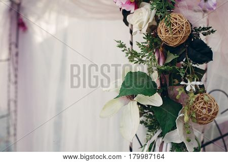 Wedding aisle archway close-up floral garland with green leaves and thread balls decoration wedding ceremony concept