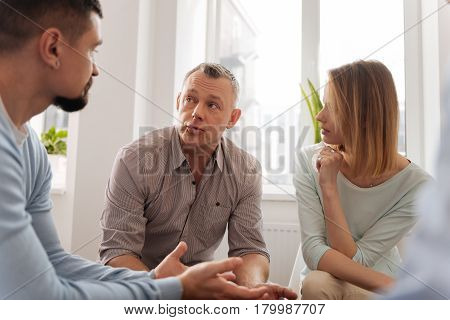 Let me say. Serious people looking at each other, sitting in circle while being at teambuilding conference