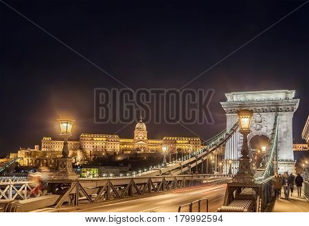 BUDAPEST HUNGARY - FEBRUARY 22 2016: Night view of the Szechenyi Chain Bridge is a suspension bridge that spans the River Danube between Buda and Pest Hungary.