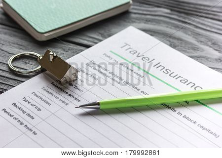 Travel preparation concept with insurance application form on wooden table background
