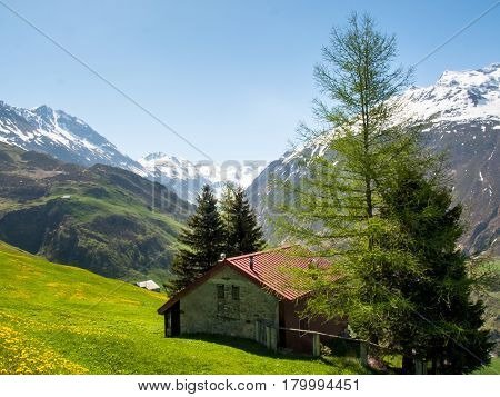 Andermatt Switzerland: View of the pastures and mountains illuminated by the sun during a beautiful day on the day of the Feast of the Ascension
