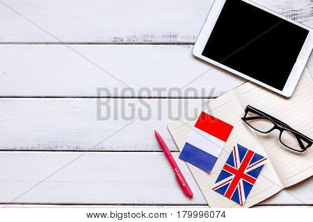 online language school lifestyle with tablet and copybook for learning on white wooden table background top view mockup