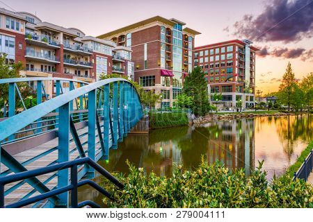 Greenville, South Carolina, USA downtown cityscape on the Reedy River at dusk.