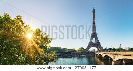 Paris Street With View On The Famous Paris Eiffel Tower On A Sunny Day With Some Sunshine
