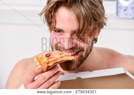 Guy Holds Pizza Box Sit Bed In Bedroom Or Hotel Room. Hungry Young Man In Underwear Sits At Home On 