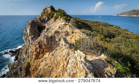 Beautiful Seascape With Rocky Cliff And Sailing Boat On The Horizon. Giglio Island (isola Del Giglio
