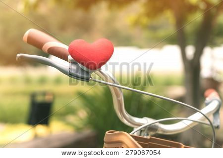 A Little Red Heart Pillow On The Bicycle Handlebar.