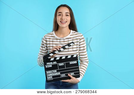 Woman With Clapperboard On Color Background. Cinema Show