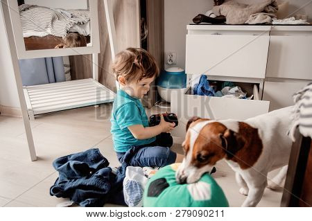 Little Toddler Boy Play At Home With His Jack Russell Terrier Dog.