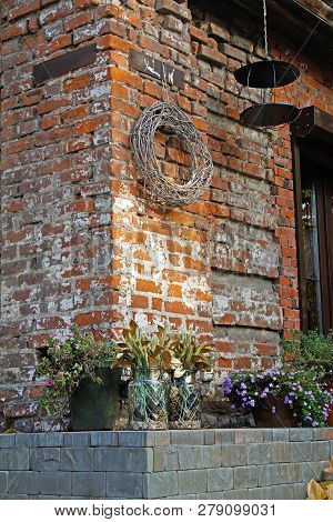 Petunia And Obrieta In Flower Pots, Cereals With Leaves In Glass Jars  As Decoration Standing Near F
