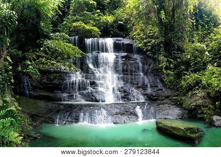 Waterfall Cascade In Tropical Rainforest With Big Rock Cover With Green Moss After Rain. Taken In Ca