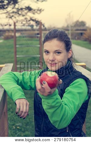 Fitnes Trainer Offering An Apple At Outdoor Gym.
