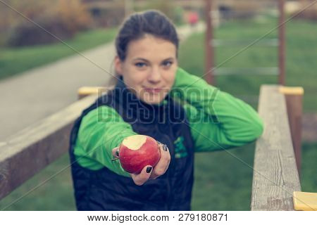 Fitnes Trainer Offering An Apple At Outdoor Gym.