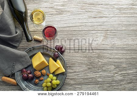 Glass And Bottle Of Red And White Wine With Food Snack On Wooden Background