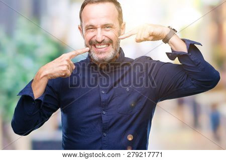 Middle age hoary senior man over isolated background smiling confident showing and pointing with fingers teeth and mouth. Health concept.