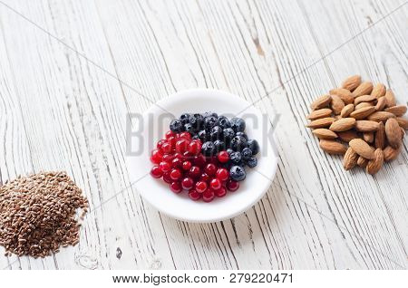Flatley With Wholesome Food On Wooden Background. On The Photo Migdal, Flax Seeds And A Saucer With 