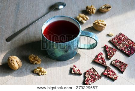 Raspberry Tea, Chocolate, Nuts And Raspberries On A Wooden Table, Selective Focus.