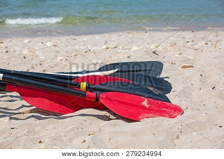 Boat Oars Lie On The Sand On The Beach By The Sea