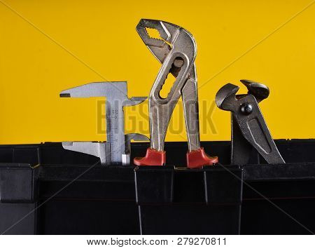 Garage Plastic Tool Box With Working Tools Isolated On A Yellow. Nippers, Wrench, Caliper