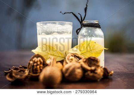 Close Up Of Akhrot Ka Dudh Or Walnut Milk On Wooden Surface With Raw Milk In  A Glass Bottle And Som