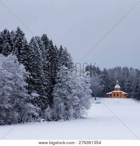 Snow Covered Chapel And Trees In The Winter Forest