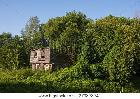 Light Blue Sky In The Warm Summer Over The Old Abondoned House Built From Wood Far Away In The Fores