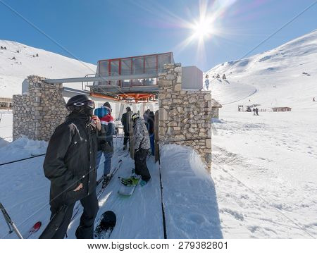 Snowboarder In The Que For The Lift