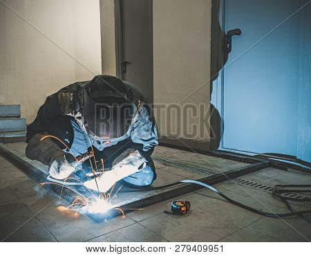 Welder Worker Performs Jump Welding. Worker Welder Performs Arc-welding Process Of Metal Structures.