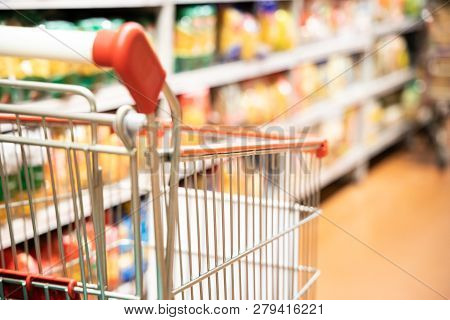 Shopping Trolley Cart With Shallow Dof Against Supermarket Aisle Background