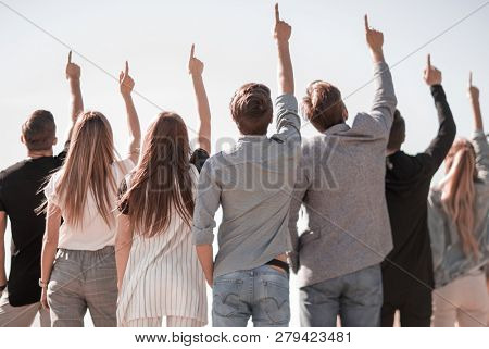 rear view. a group of business youth pointing up at a copy space