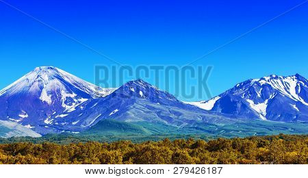 The Avachinsky And Kozelsky Volcanoes In Kamchatka In The Autumn With A Snow-covered Top