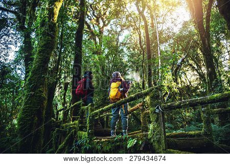 Couples Traveling, Relax In Winter.enjoy Hiking Walking Travel To Study Nature In The Rainforest. At
