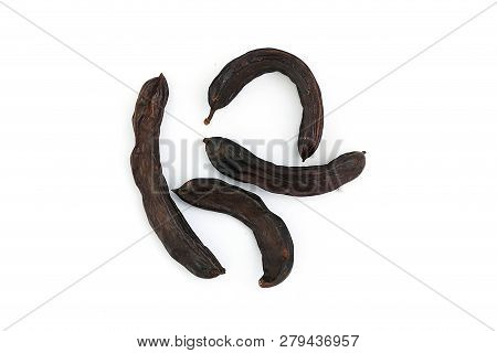 Locust Bean On A White Background,
Carob On A Plate, On A White Background