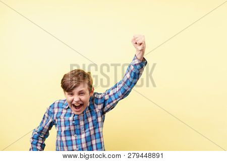 Victory, Success, Achievement. Excited Thrilled Agitated Boy Making Win Gesture Over Yellow Backgrou