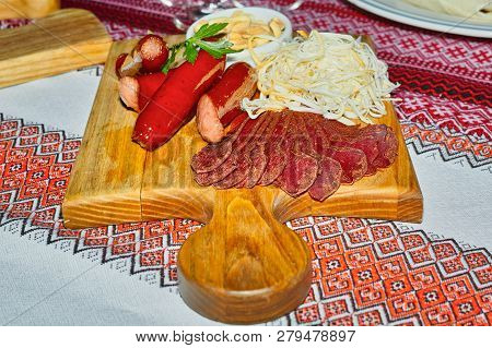 Board For Beer, With Cuts Of Cured Meat, Grilled Sausages And Cheese, With A Vase Of Peanuts.
