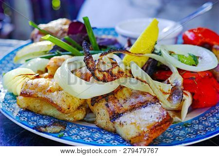 Grilled Fish Steaks With Onions, A Slice Of Lemon And Tomato.