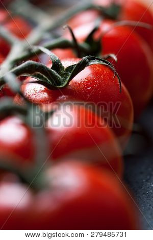 Closeup Of Fresh Cherry Tomatoes On A Black Stone Background, Selective Focus