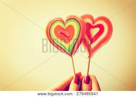 Colorful Heart Shaped Lollipops In Woman Hand