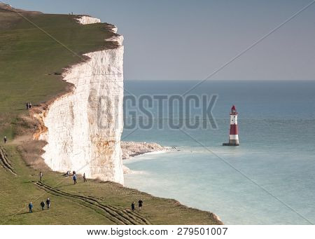 Beachy Head And Lighthouse. A View Of The Imposing Chalk Cliff Face Known As Beachy Head On The Sout