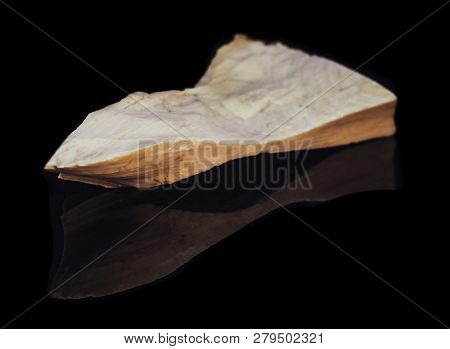 Piece Of Natural Petrified Wood With Opal On Black Background With Reflection