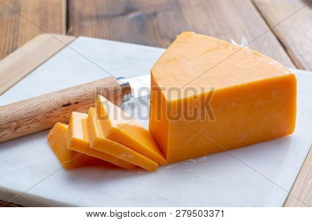 Piece Of Bright Yellow Hard Cheese Cheddar, Originating In The English Village Of Cheddar In Somerse