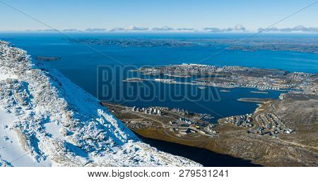 Greenlands capital Nuuk - largest city in Greenland aerial view. Drone image of Nuuk from air, aka Godthaab seen from Mountain Sermitsiaq also showing Nuup Kangerlua fjord.