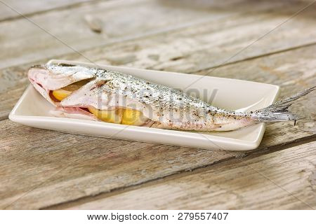 Fish Stuffed With Lemons. Stuffed Dorado Fish On White Plate.