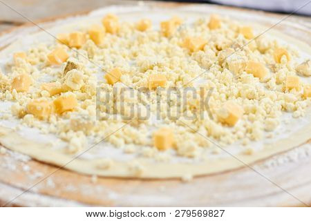 Cheese Dices On Pizza. Uncooked Pizza Crust With Little Cheese Pieces.