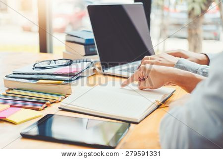 High School Or College Students Studying And Reading Together In Library
