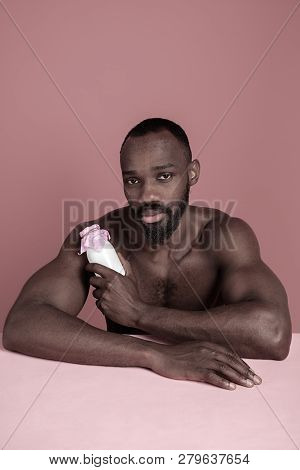 Healthy Young African Man Holging Little Bottle Of Milk On A Pink Studio Background. Close Up Portra