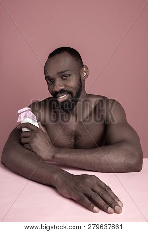 Healthy Young African Man Holging Little Bottle Of Milk On A Pink Studio Background. Close Up Portra