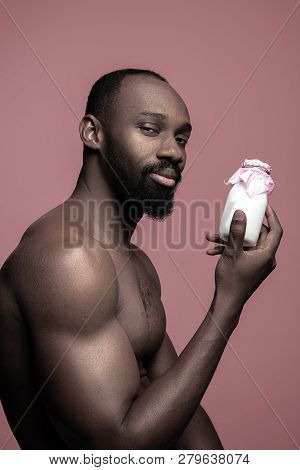 Healthy Young African Man Holging Little Bottle Of Milk On A Pink Studio Background. Close Up Portra